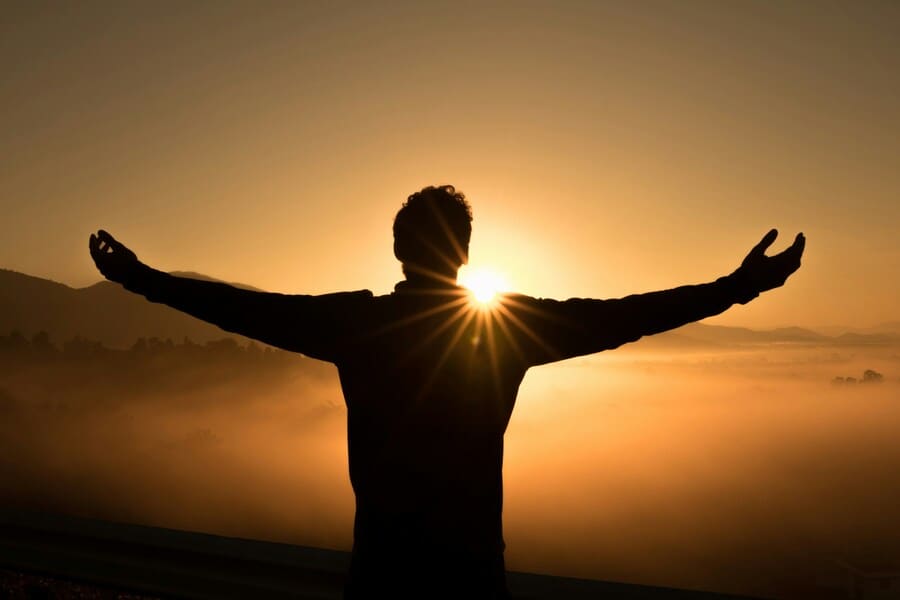 Early retirement joy in an image of a man welcoming sunrise